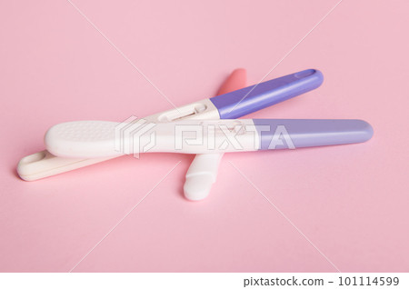 Rapid diagnosis of pregnancy at home. Pregnancy test kits with two bars on isolated pink pastel background. Copy ad space. Women's health, gynecology and medicine concept. Planning maternity concept Rapid diagnosis of pregnancy at home. Pregnancy test kits with two bars on isolated pink pastel background. Copy ad space. Women's health, gynecology and medicine concept. Planning maternity concept 101114599