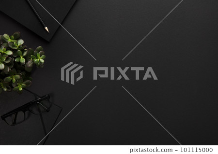 Top view of black office desk with notebook and supplies Top view of black office desk with notebook and supplies 101115000
