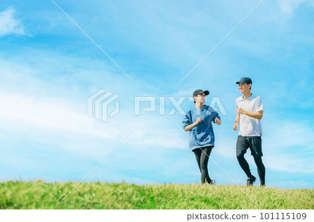 A smiling Japanese man and woman jogging under the blue sky A smiling Japanese man and woman jogging under the blue sky 101115109