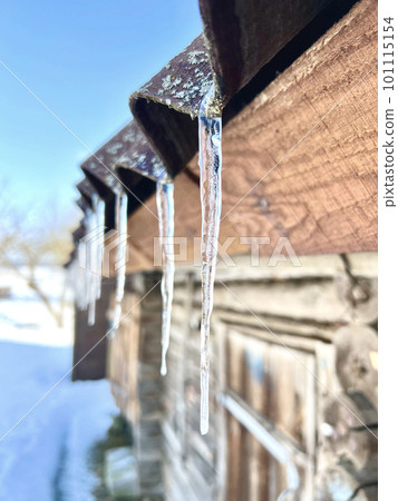 Icicles on the roof melt in the spring sun. Selective focus Icicles on the roof melt in the spring sun. Selective focus 101115154