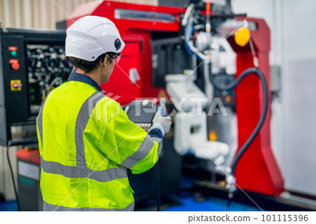 Back of professional technician or engineer use controller to work with factory robotic arm machine Back of professional technician or engineer use controller to work with factory robotic arm machine 101115396