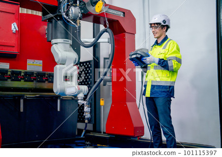 Young engineer or technician worker man use controller to work with big robotic arm machine Young engineer or technician worker man use controller to work with big robotic arm machine 101115397