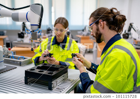 Side view of Caucasian engineer or technician workers man and woman check piece of machine 101115728