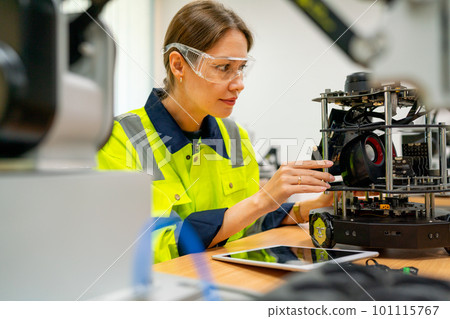 Pretty Caucasian professional engineer or technician worker woman check and maintenance small robot Pretty Caucasian professional engineer or technician worker woman check and maintenance small robot 101115767