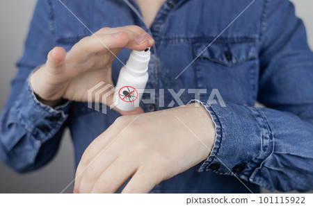 Tick repellant. Insect protection. Girl holds a spray on a white background that will protect against ticks. Repelling blood-sucking insects. 101115922