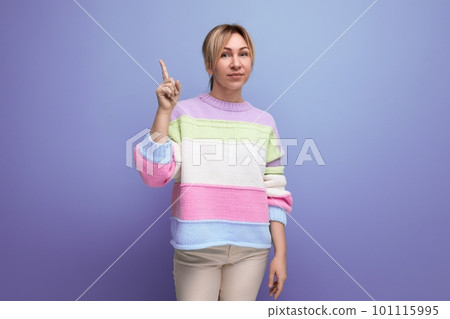 blond brilliant young woman in casual outfit with a good idea on a purple background with copy space 101115995