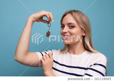cute happy young woman is the owner of a new apartment on a blue isolated background 101116005
