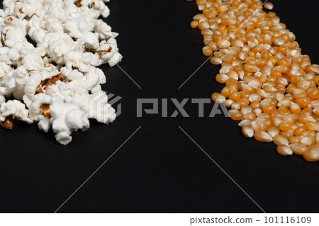 a row of ready-made popcorn and a row of corn kernels on a black background, place for inscription and advertising. 101116109