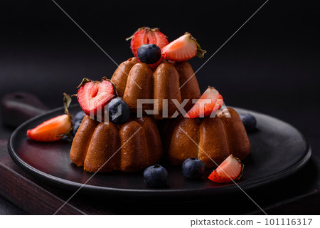 Delicious cupcakes or muffins with raisins and nuts, strawberries and blueberries 101116317