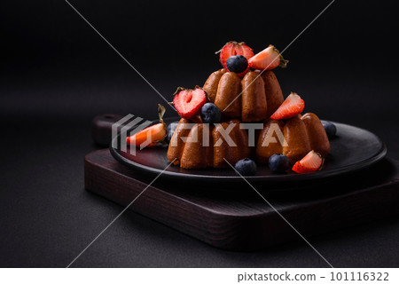 Delicious cupcakes or muffins with raisins and nuts, strawberries and blueberries 101116322