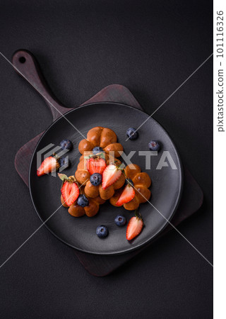 Delicious cupcakes or muffins with raisins and nuts, strawberries and blueberries 101116326