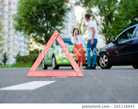 A guy and a girl are arguing near their cars as a result of an accident on the road. Head-on collision of two cars. 101116843