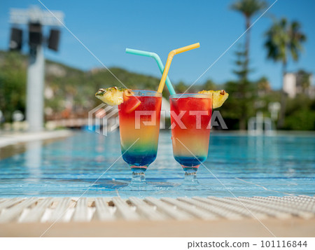 Relax by the pool. Summer vibrant cocktails with a straw sit by the pool. 101116844