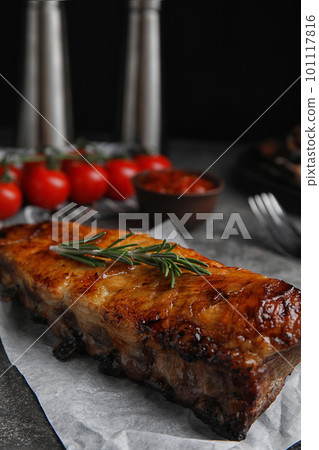 Tasty grilled ribs with rosemary on grey table 101117816