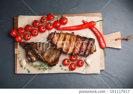 Tasty grilled ribs on black table, flat lay 101117817