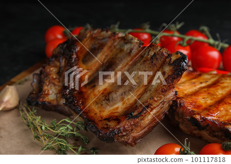 Tasty grilled ribs with tomatoes on table, closeup Tasty grilled ribs with tomatoes on table, closeup 101117818