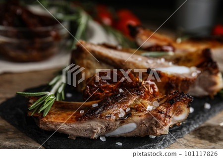Tasty grilled ribs with rosemary on wooden table, closeup 101117826