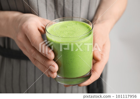 Woman holding tasty fresh kale smoothie, closeup Woman holding tasty fresh kale smoothie, closeup 101117956