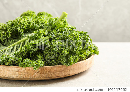 Fresh kale leaves on light grey table, closeup Fresh kale leaves on light grey table, closeup 101117962