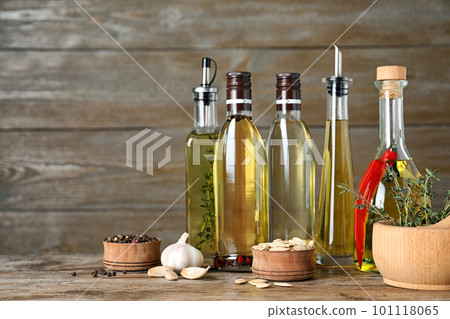Different cooking oils in bottles on wooden table 101118065