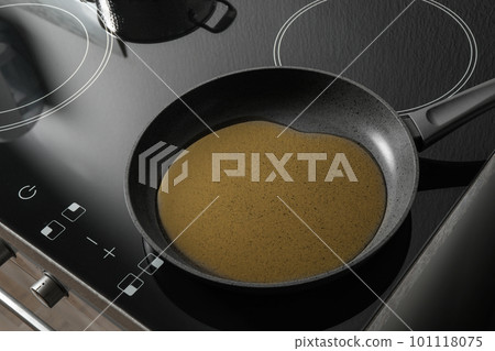 Frying pan with cooking oil on induction stove Frying pan with cooking oil on induction stove 101118075
