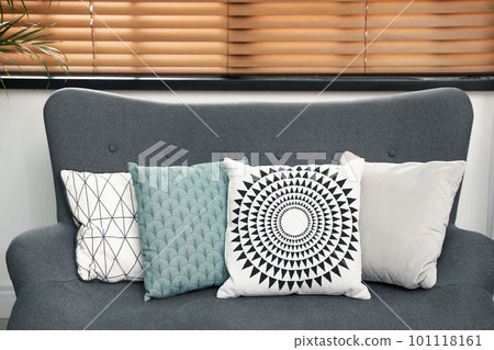 Stylish decorative pillows on grey couch indoors, closeup 101118161