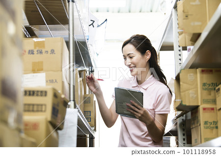 A woman who manages inventory in a warehouse A woman who manages inventory in a warehouse 101118958
