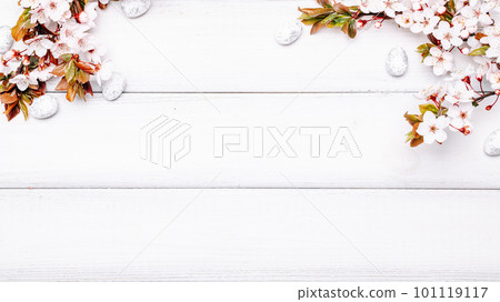 Easter white background. Spring flower border, white happy easter egg on wooden spring background. Easter card. Flat lay. 101119117