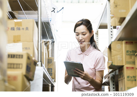 A woman who manages inventory in a warehouse A woman who manages inventory in a warehouse 101119309