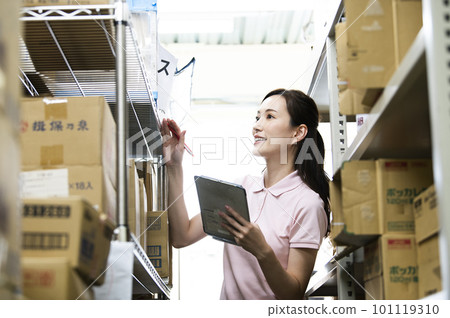 A woman who manages inventory in a warehouse A woman who manages inventory in a warehouse 101119310