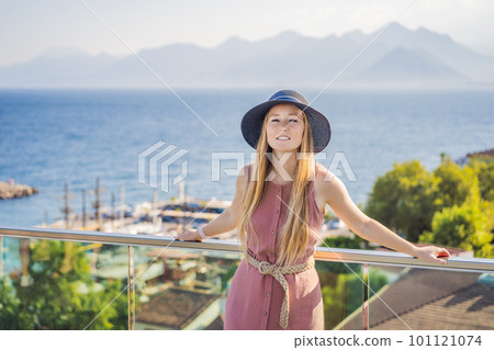 Woman tourist in Old town Kaleici in Antalya. Turkiye. Panoramic view of Antalya Old Town port, Taurus mountains and Mediterrranean Sea, Turkey 101121074