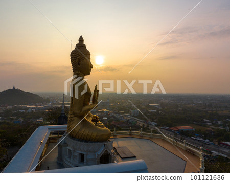 aerial view The sun was on the hand of the golden Buddha in Phetchaburi. aerial view scenery golden sky in the morning at the golden Buddha on the high mountain. bright yellow sky background. aerial view The sun was on the hand of the golden Buddha in Phetchaburi. aerial view scenery golden sky in the morning at the golden Buddha on the high mountain. bright yellow sky background. 101121686