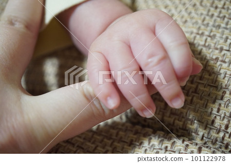 Photo of a baby's hand holding an adult's finger Photo of a baby's hand holding an adult's finger 101122978
