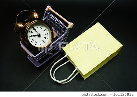 Trolley cart and shopping bag with alram clock with space copy on black background 101125932