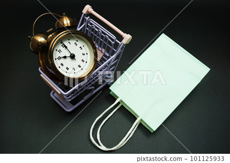 Trolley cart and shopping bag with alram clock with space copy on black background 101125933