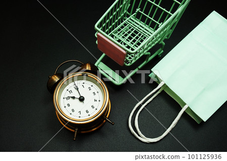 Trolley cart and shopping bag with alram clock with space copy on black background Trolley cart and shopping bag with alram clock with space copy on black background 101125936