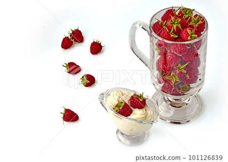 Red raspberries in a glass gravy boat with cream and in a glass goblet Red raspberries in a glass gravy boat with cream and in a glass goblet 101126839