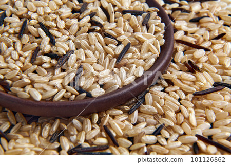 A mixture of brown and black unpolished wild rice in a clay ceramic bowl close-up A mixture of brown and black unpolished wild rice in a clay ceramic bowl close-up 101126862