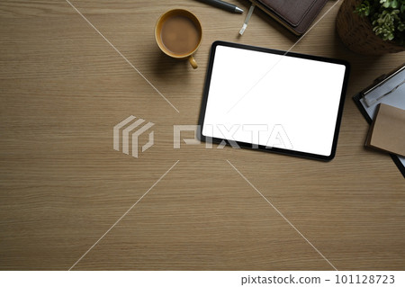 Flat lay, top view of simple workspace with digital tablet, cup of coffee and notebook on wooden table 101128723