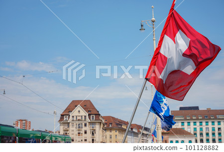 Beautiful Swiss flag is waving front of historical street in Basel, Switzerland Beautiful Swiss flag is waving front of historical street in Basel, Switzerland 101128882