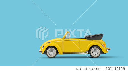 Miniature yellow toy convertible car on blue background with copyspace 101130139