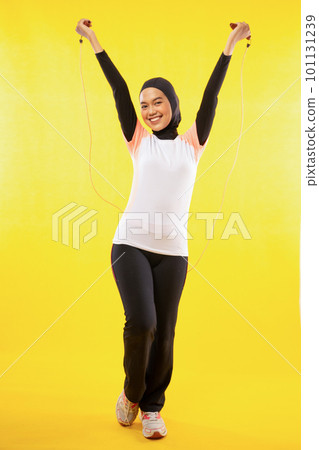 Muslim woman exercise skipping rope with hands raise with yellow 101131239