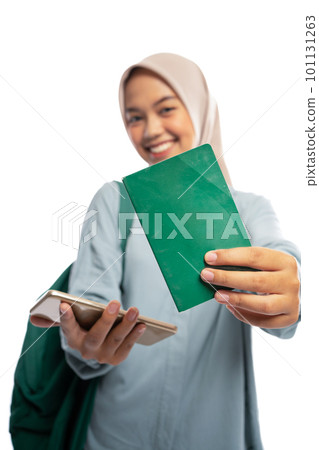 Muslim woman showing account book and cell phone on white Muslim woman showing account book and cell phone on white 101131263