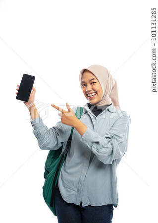 Asian Muslim female student pointing at cell phone on white Asian Muslim female student pointing at cell phone on white 101131285