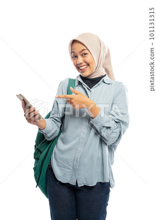 Asian female hijab student pointing at cell phone on white Asian female hijab student pointing at cell phone on white 101131315