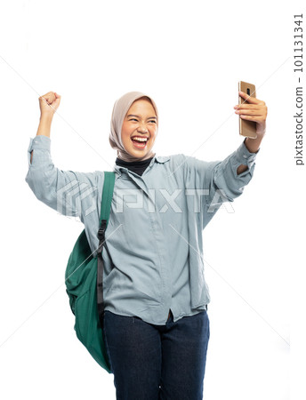 excited female hijab student taking selfie using phone in isolated excited female hijab student taking selfie using phone in isolated 101131341