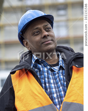 Portrait of an Indian civil engineer or factory worker wearing a safety blue helmet and plaid shirt 101131586