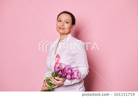 Pleasant pregnant woman wearing a pink satin ribbon, showing her support for cancer patients and survivors, looking away at copy space, isolated background. Pink October, Breast Cancer Awareness Month 101131719