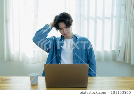 A young man holding his head in telework A young man holding his head in telework 101133500