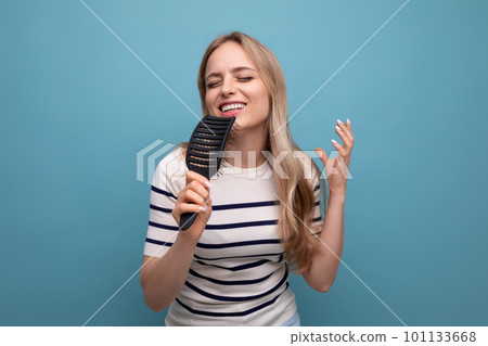 cute well-groomed european blond woman with healthy hair after a visit to the trichologist on a blue 101133668